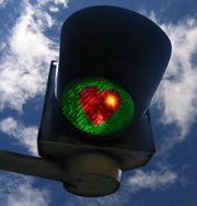 Ampel mit rotem Herz auf grünem Hintergrund Ampel mit rotem Herz auf grünem Hintergrund